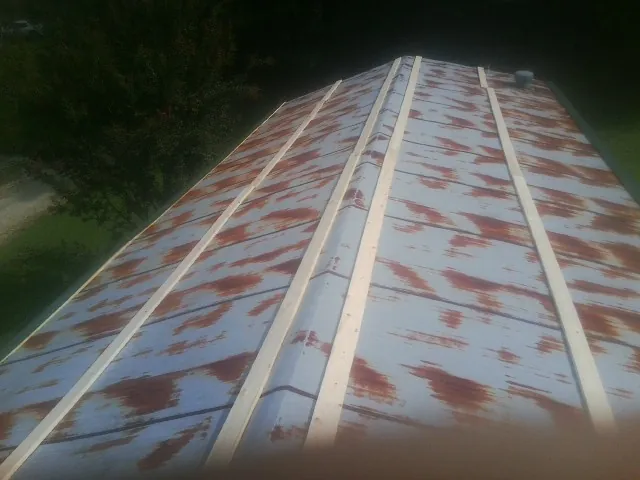 Rusted metal roof panels with new wood purlins before replacement — Storm Damage Roof Repair in Cadillac by Roofing Brothers